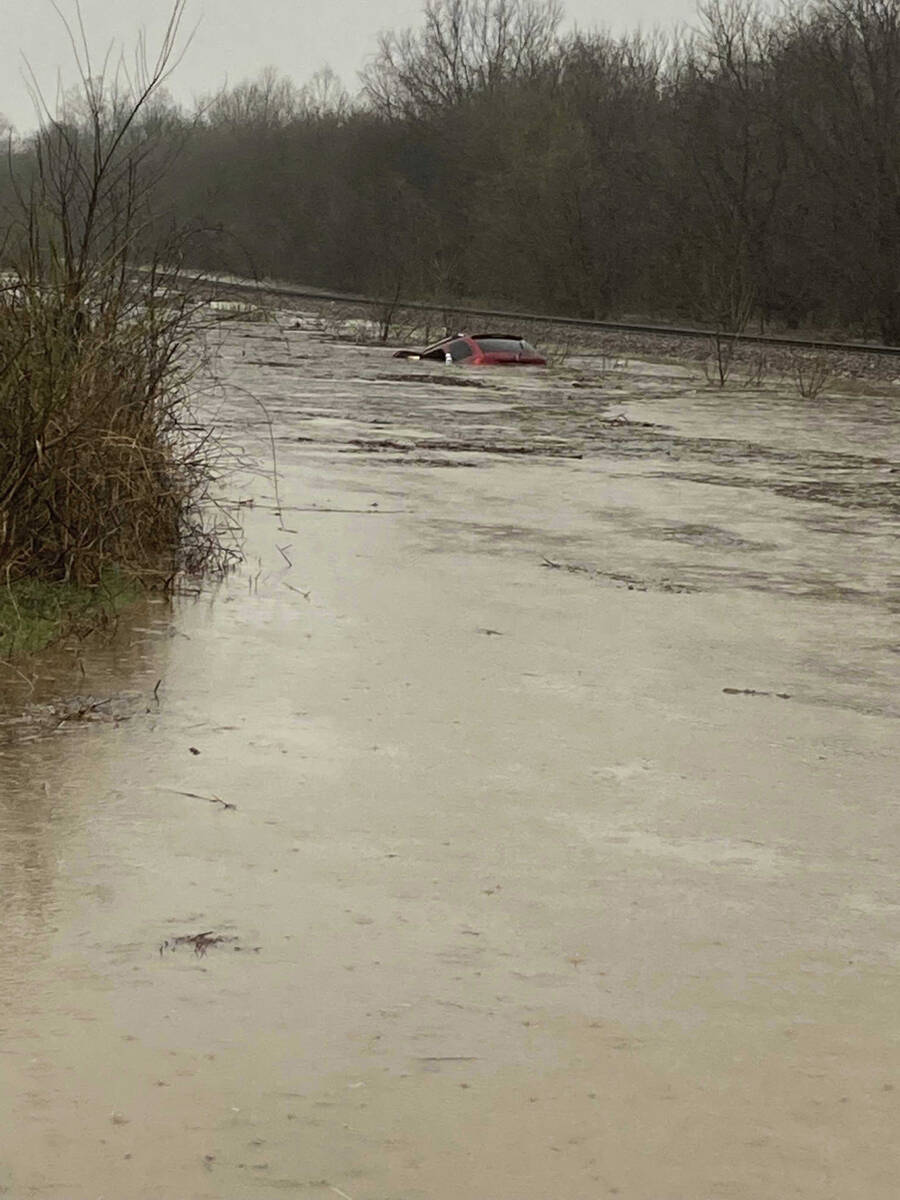 In this photo provided by Layton Hoyer, a red SUV is seen submerged in floodwater on Old Ritche ...
