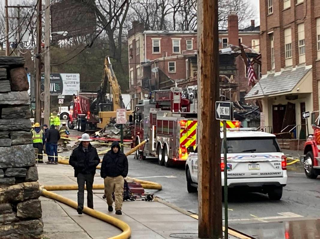 Emergency personnel and heavy equipment work at the site of a deadly explosion at a chocolate f ...