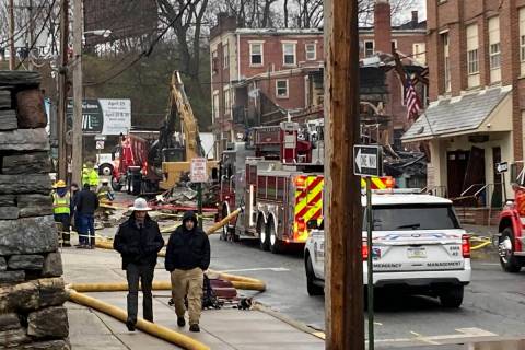 Emergency personnel and heavy equipment work at the site of a deadly explosion at a chocolate f ...