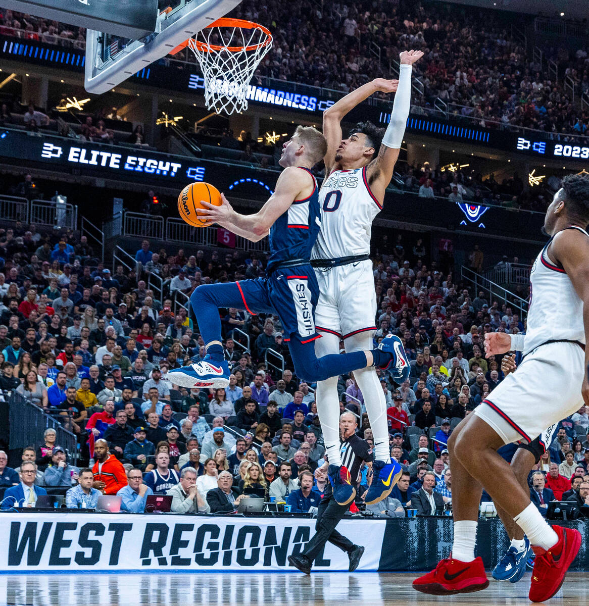 UConn guard Joey Calcaterra (3) gets inside of Gonzaga guard Julian Strawther (0) for a basket ...