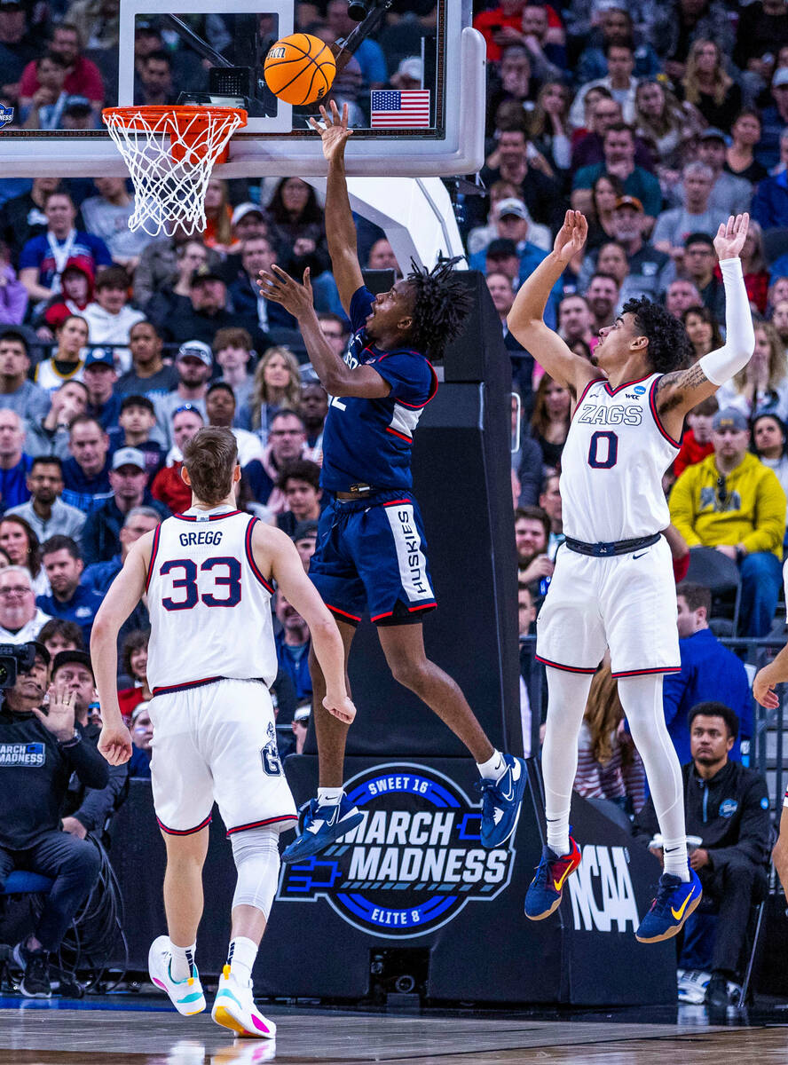 UConn guard Tristen Newton (2) gets inside of Gonzaga guard Julian Strawther (0) for another sc ...