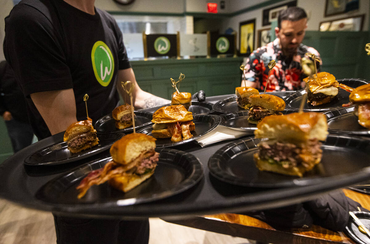 Burger samples are passed out during the opening celebration of a new Wahlburgers at The Shoppe ...