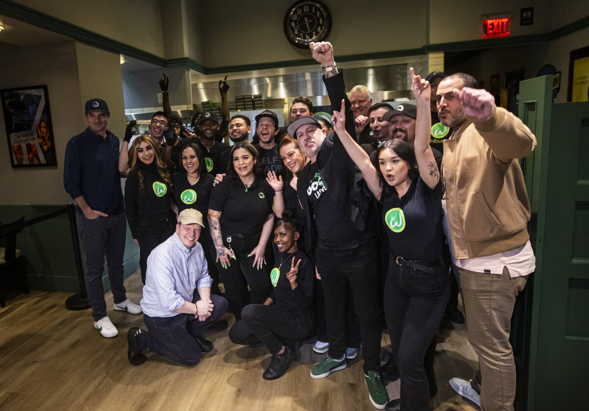The staff of Wahlburgers pose for a photo with brothers Paul Wahlberg, lower left, and Mark Wah ...