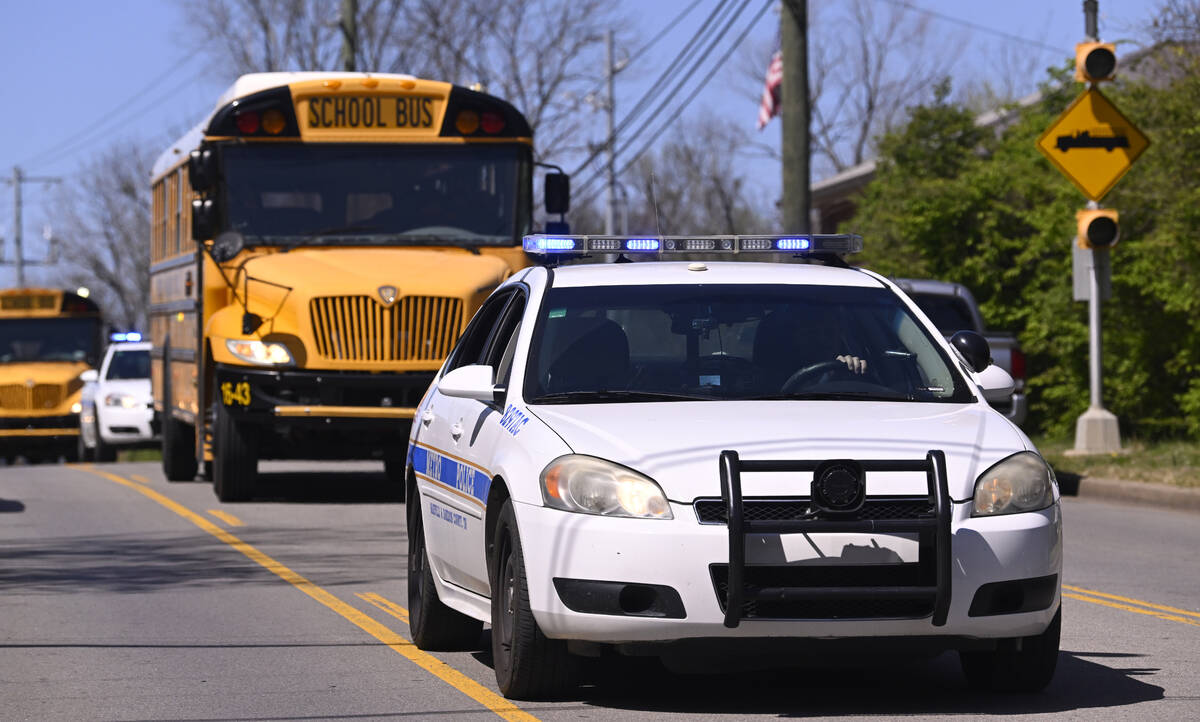 Metro Nashville Police cars escort evacuees on school buses as they leave The Covenant School i ...