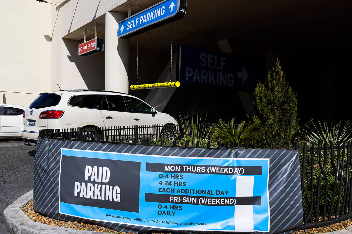 Paid parking sign is seen as a car enters a parking garage at The Strat, on Monday, March 27, 2 ...