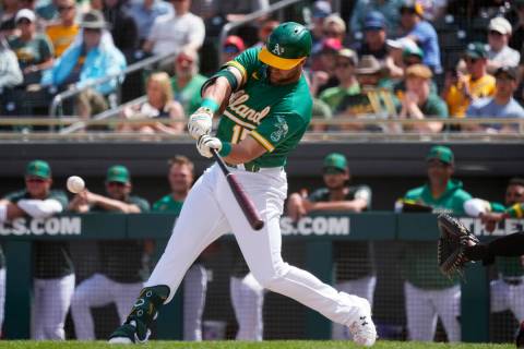 Oakland Athletics' Seth Brown starts his swing on a run-scoring single against the San Francisc ...