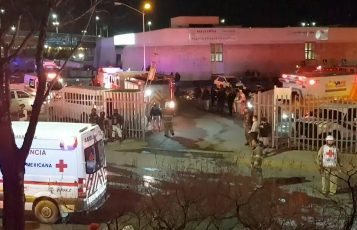 Ambulances and rescue teams staffers are seen outside an immigration center in Ciudad Juarez, M ...