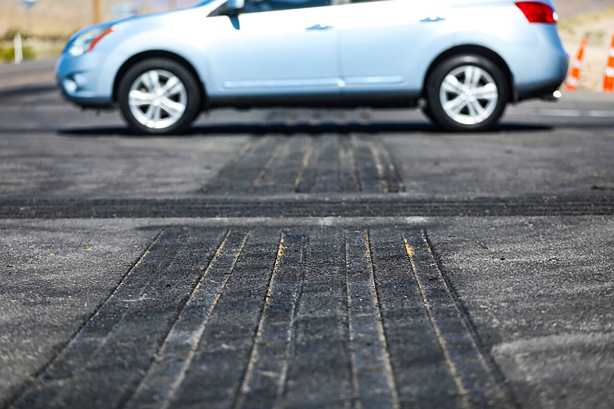 A motorist drives over a safety transverse rumble strip at the intersection of US 93 and Grand ...