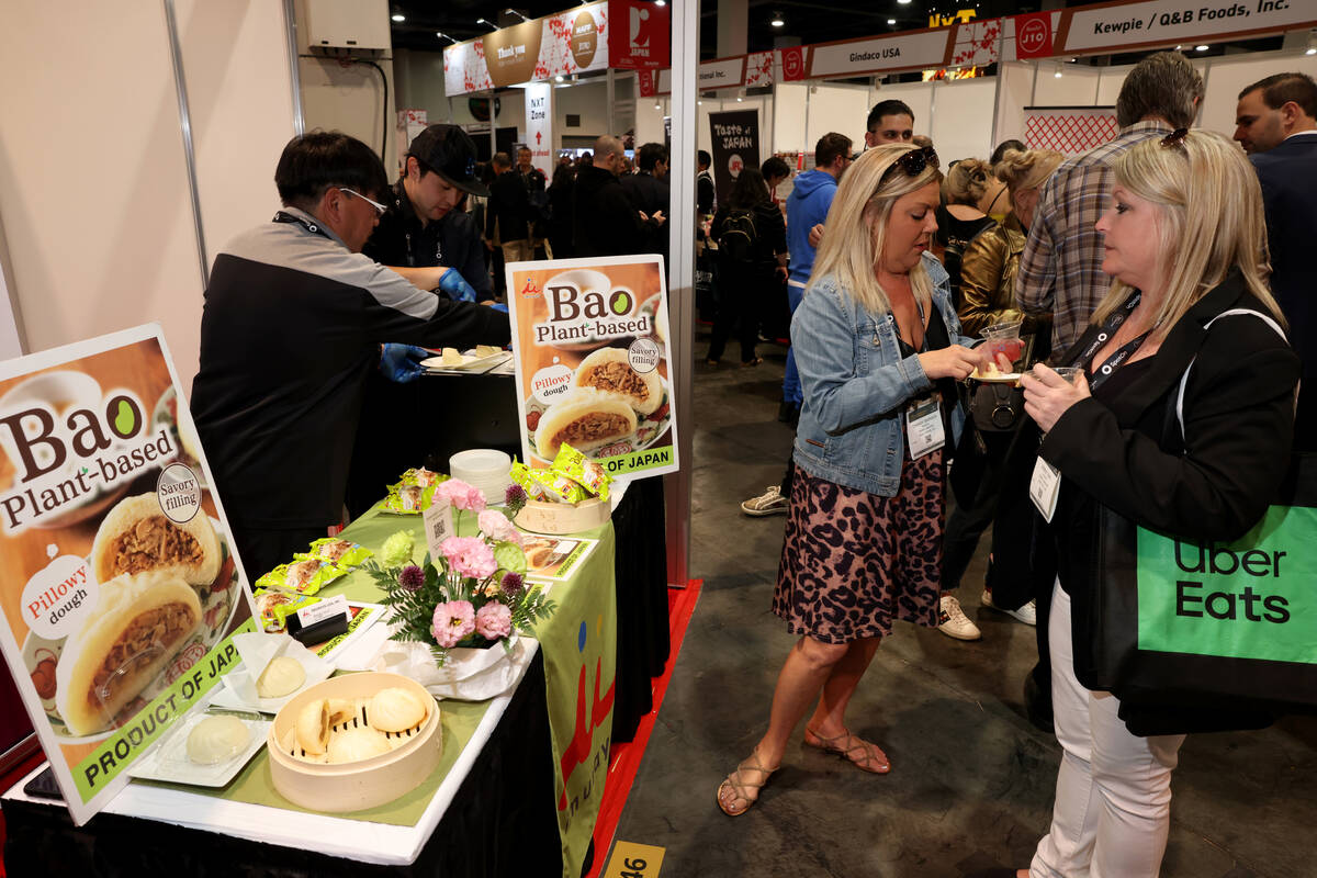 Conventioneers sample plant based bao at the Imuraya USA booth at the Bar & Restaurant Expo ...