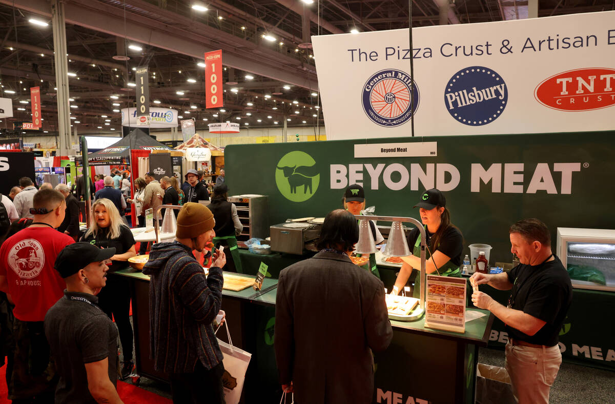 Conventioneers sample pizza at the Beyond Meat booth at the International Pizza Expo at the Las ...