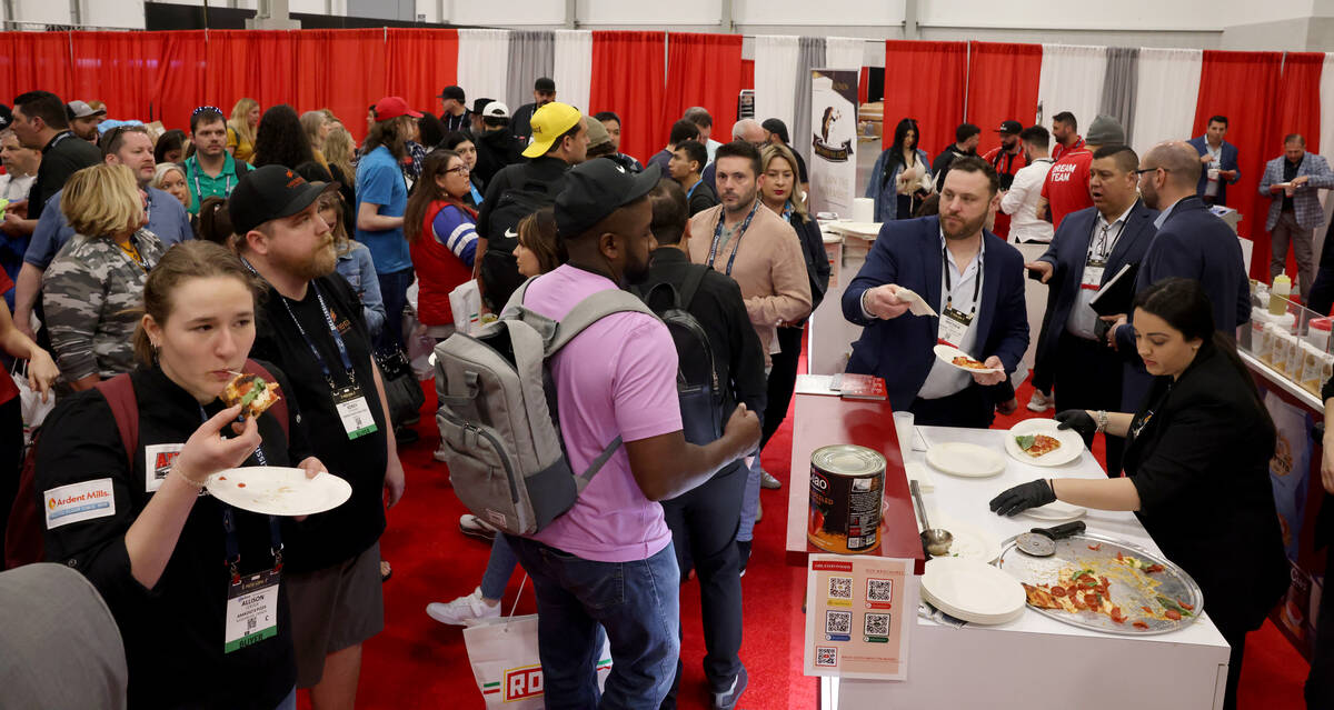 Conventioneers sample pizza at the Orlando Foods booth at the International Pizza Expo at the L ...