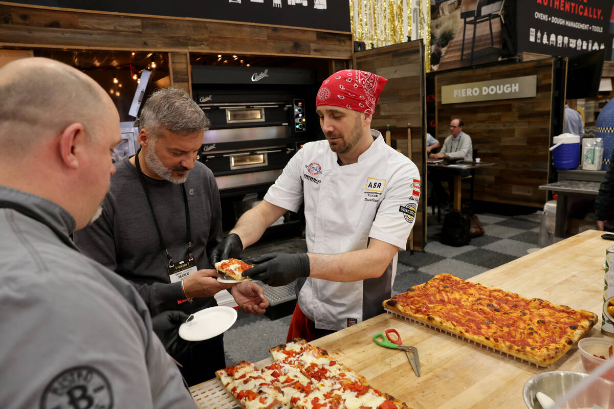 Pizza Artista Massimiliano Saieva of ASR PizzaLab academy gives a pizza sample to Marco Acunto ...