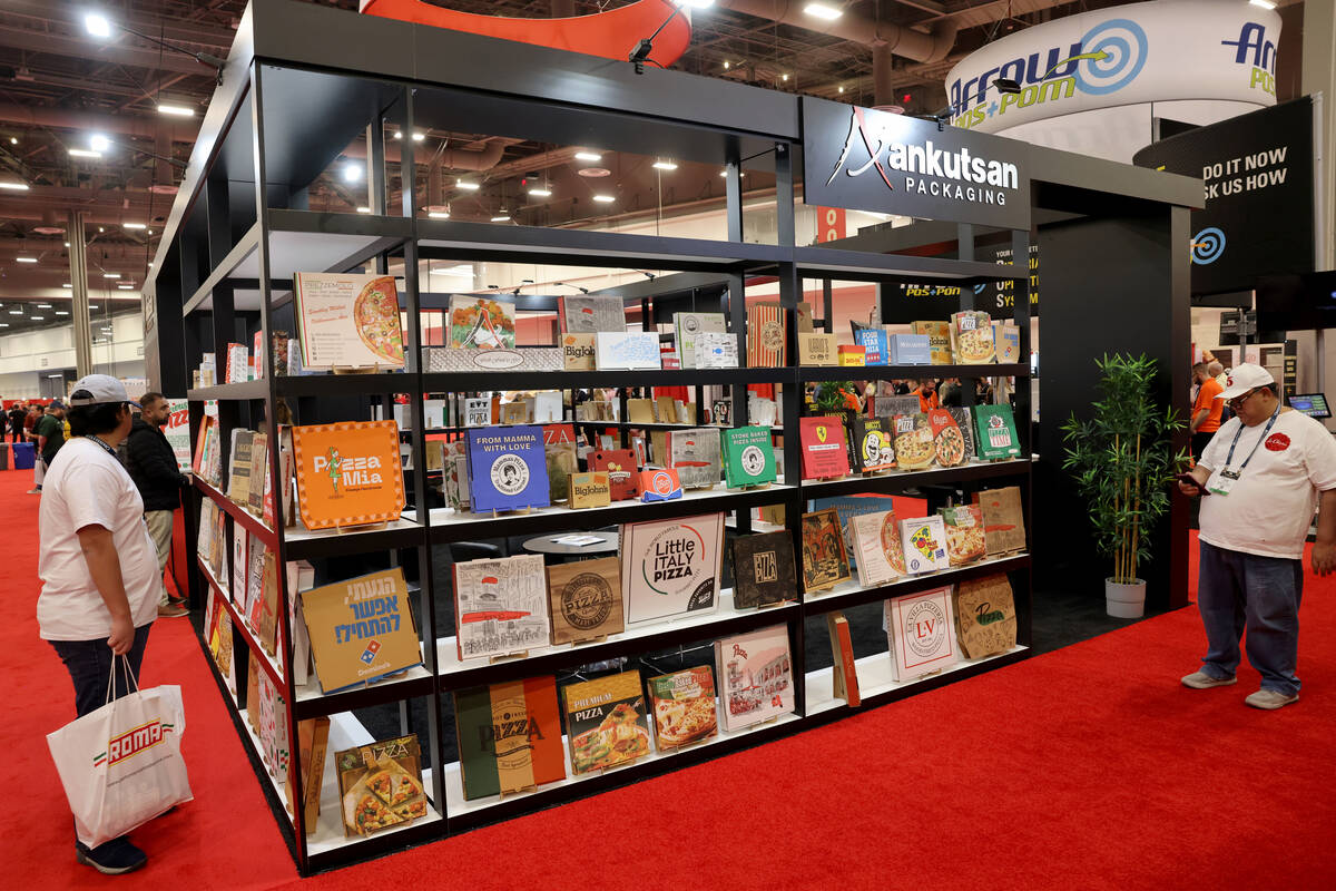 Conventioneers check out pizza boxes on display at the Ankutsan Packaging booth at the Internat ...