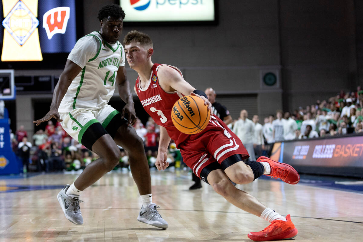 Wisconsin Badgers guard Connor Essegian (3) drives around North Texas Mean Green guard Arsh Mat ...