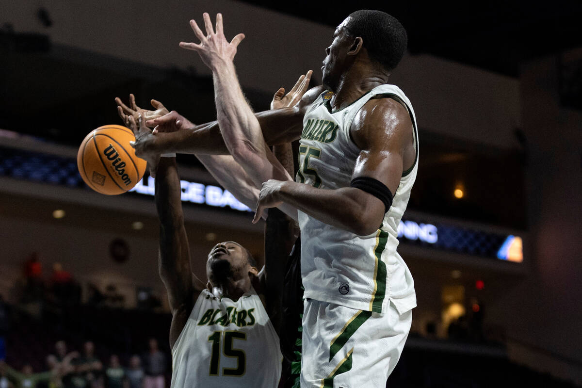 UAB Blazers center Trey Jemison (55) and forward Ty Brewer (15) deny a shot by Utah Valley Wolv ...