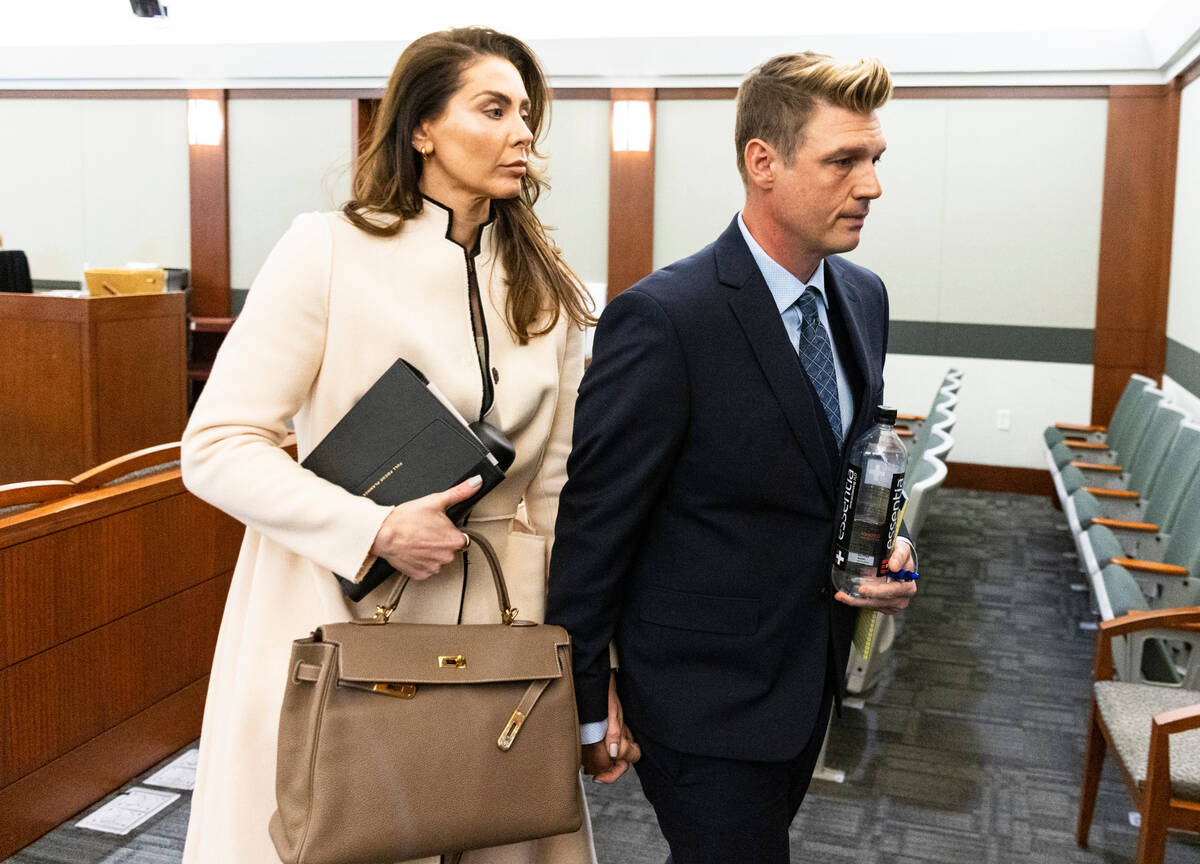 Nick Carter, a member of the Backstreet Boys, leaves the courtroom with his wife Lauren Kitt af ...