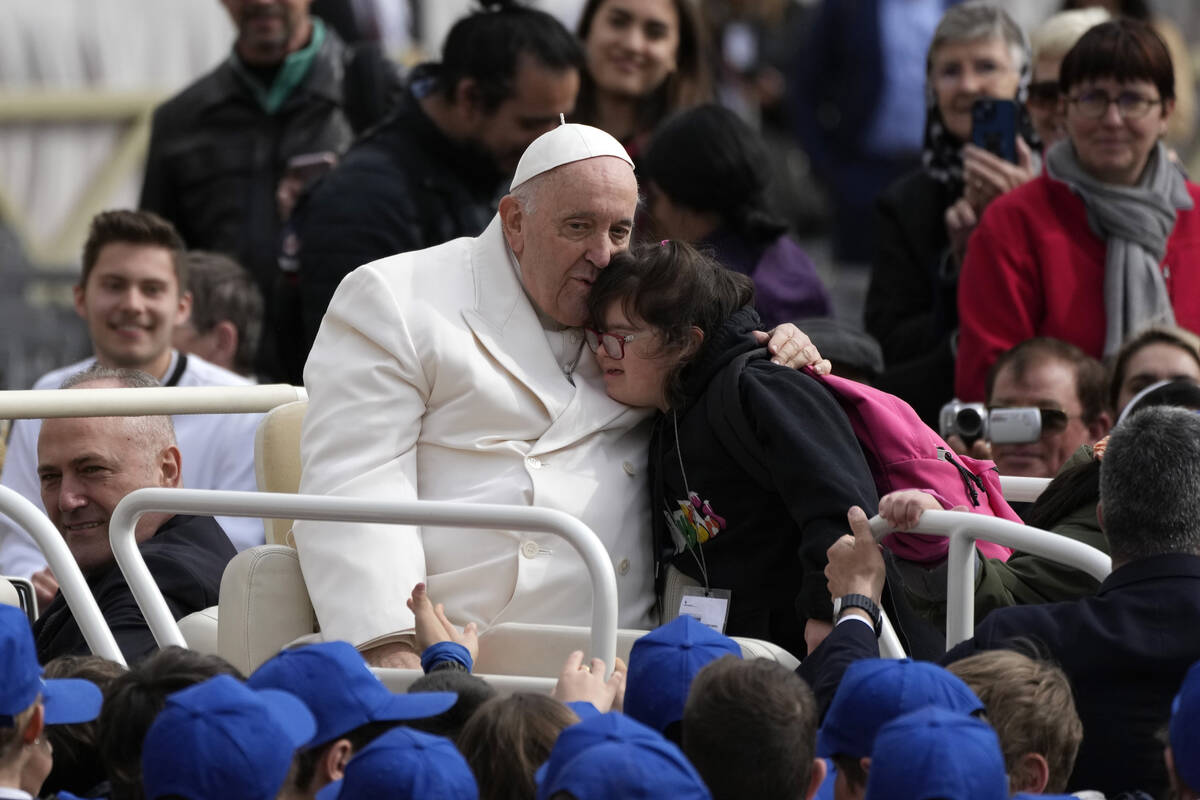 Pope Francis hugs a child at the end of his weekly general audience in St. Peter's Square, at t ...