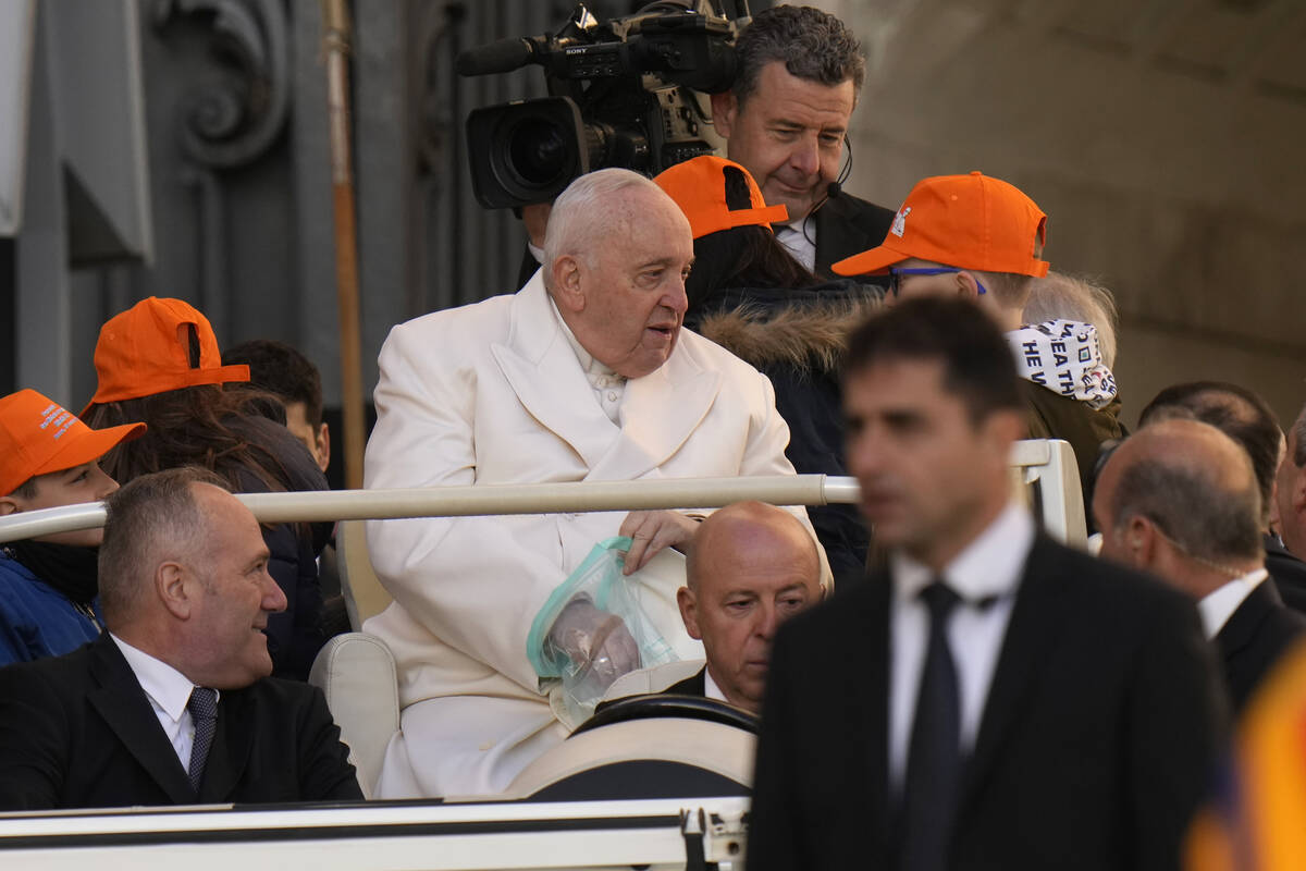 Pope Francis holds a plastic bag as he arrives for his weekly general audience in St. Peter's S ...