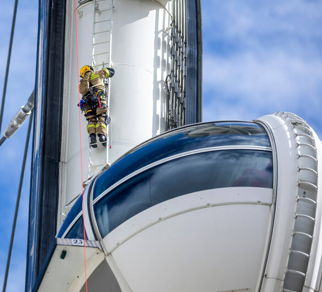 A member of the Clark County Fire Department’s heavy rescue team ascends the High Roller whil ...