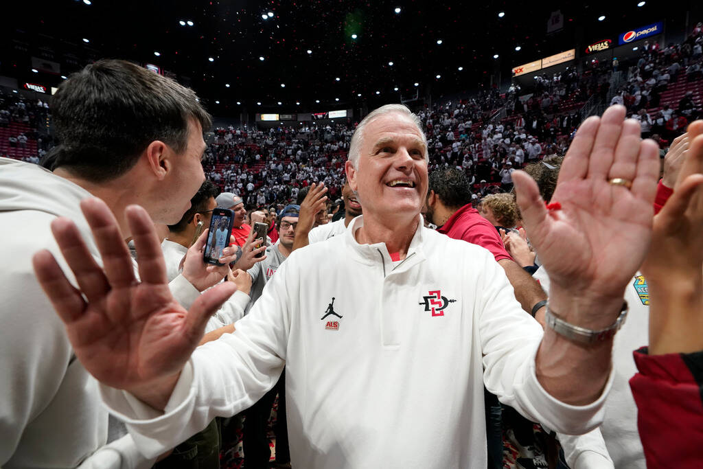 FILE - San Diego State head coach Brian Dutcher reacts with fans after San Diego State defeated ...