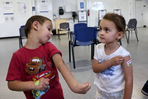 Three-year-old twins Luca, left, and Quincy Yacoub show off their Band-Aids after getting a COV ...