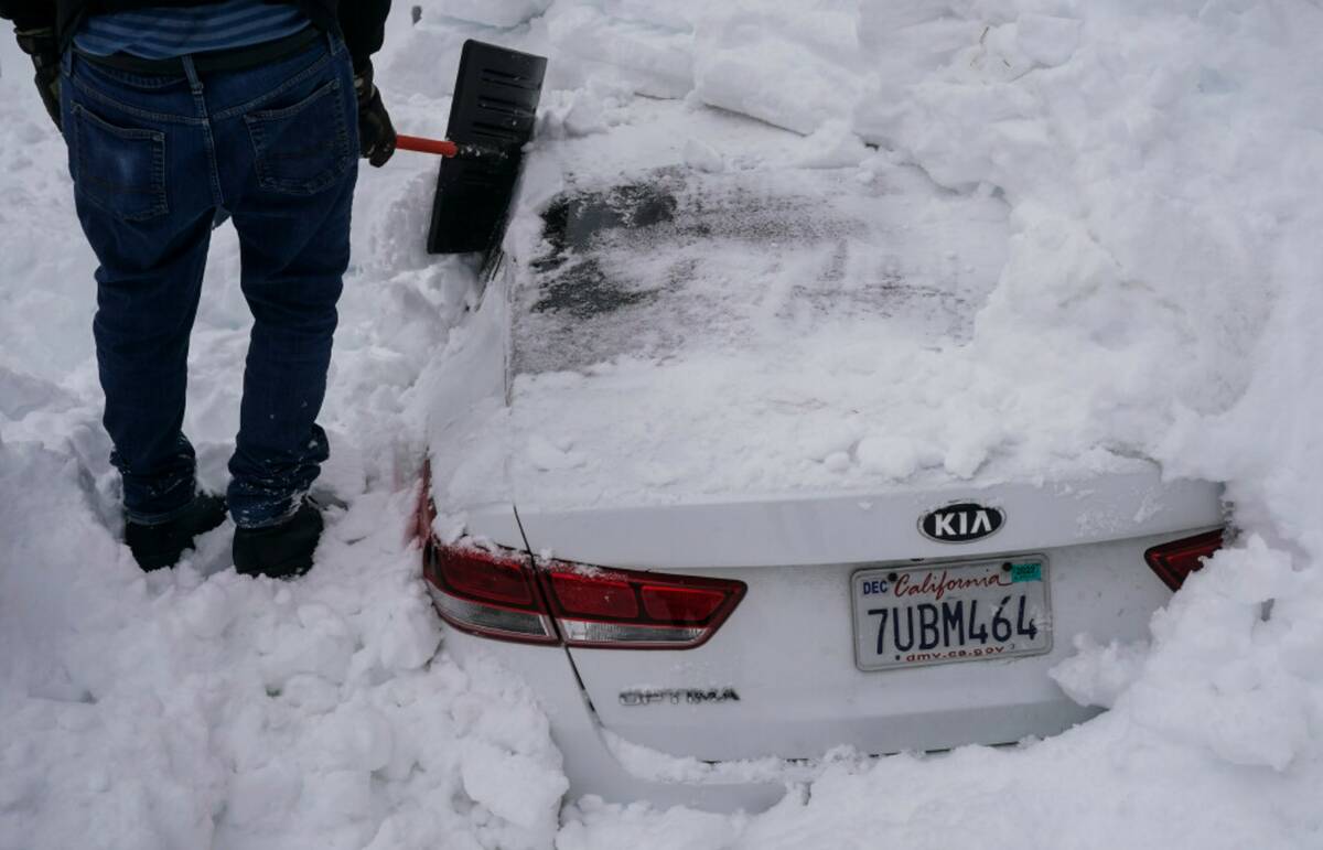 Kenny Rybak, 31, shovels snow around his car in Running Springs, Calif., Tuesday, Feb. 28, 2023 ...