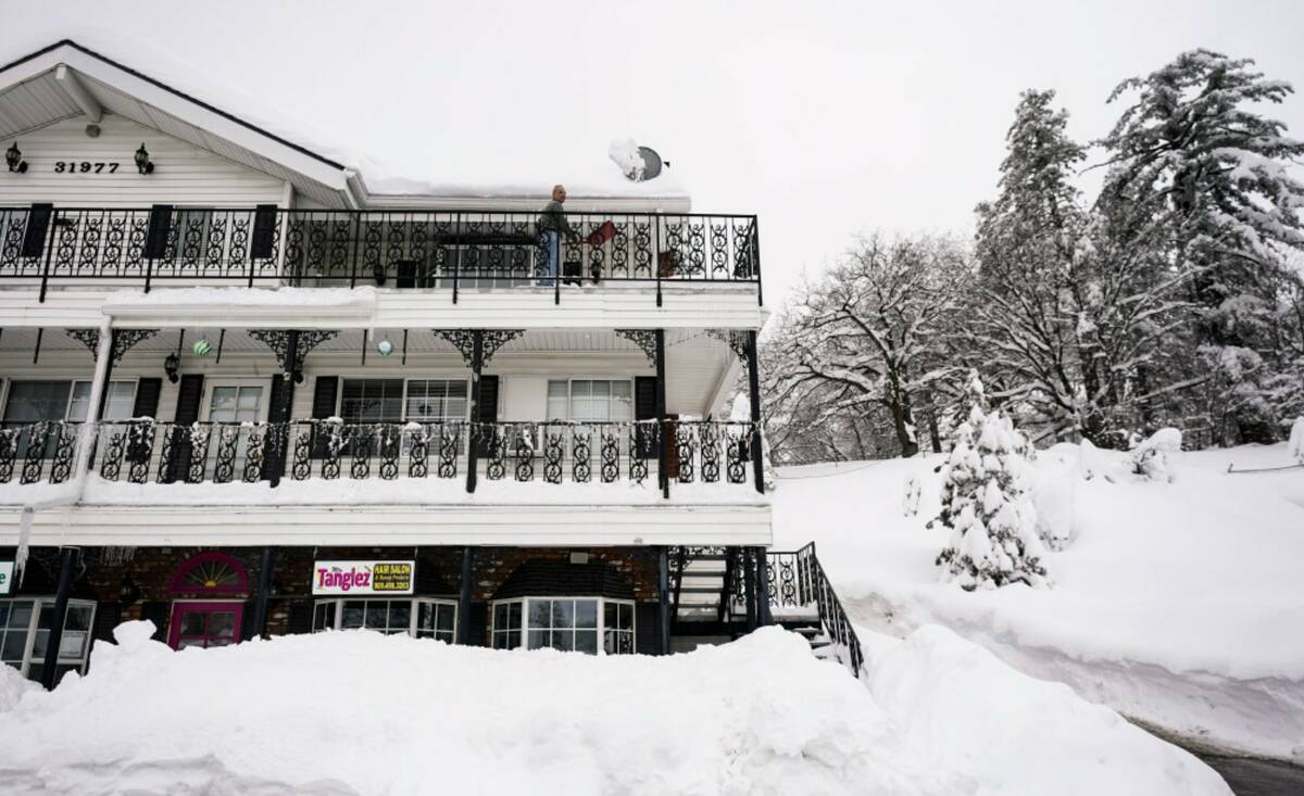 Anthony Camino, 51, shovels snow in Running Springs, Calif., Tuesday, Feb. 28, 2023. (AP Photo/ ...