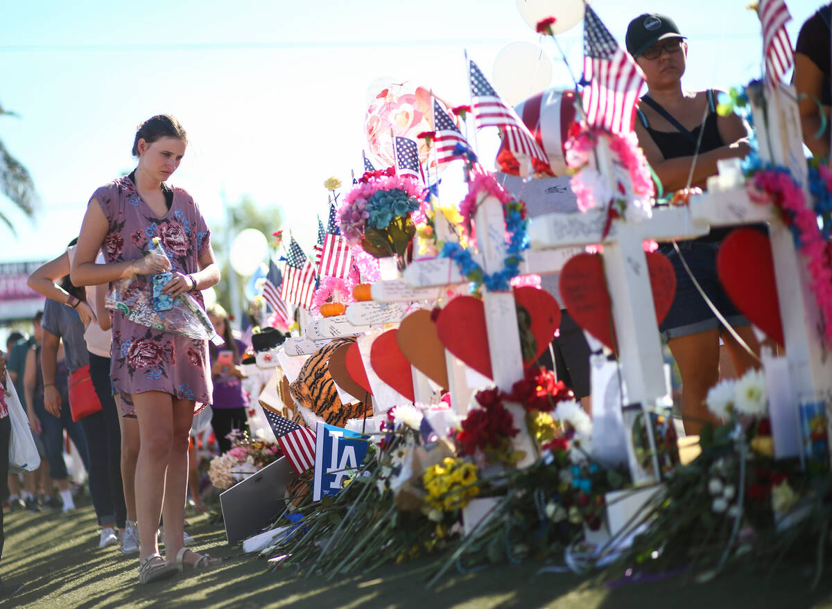 Kylie Wright of Flagstaff, Ariz., leaves behind roses at a makeshift memorial near the "Welcome ...