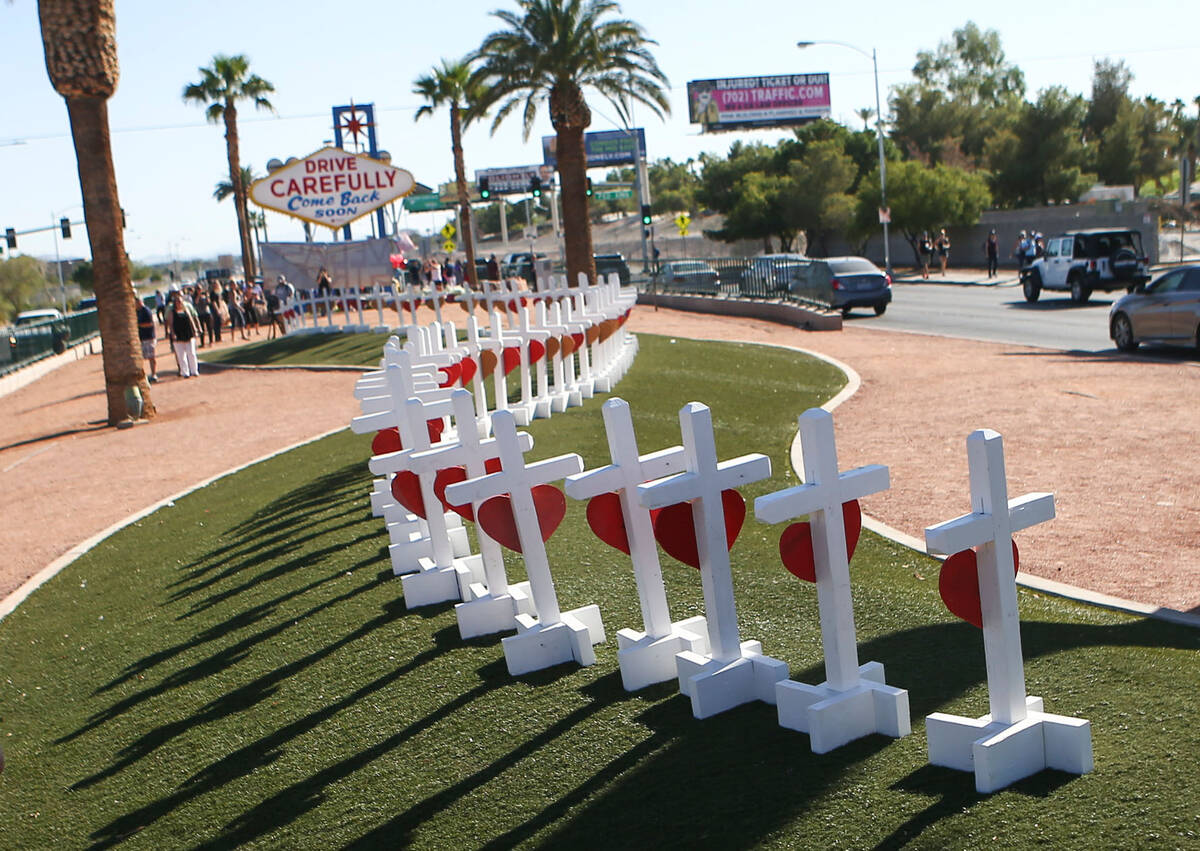 People take pictures of crosses near the "Welcome to Fabulous Las Vegas" sign in Las Vegas on O ...