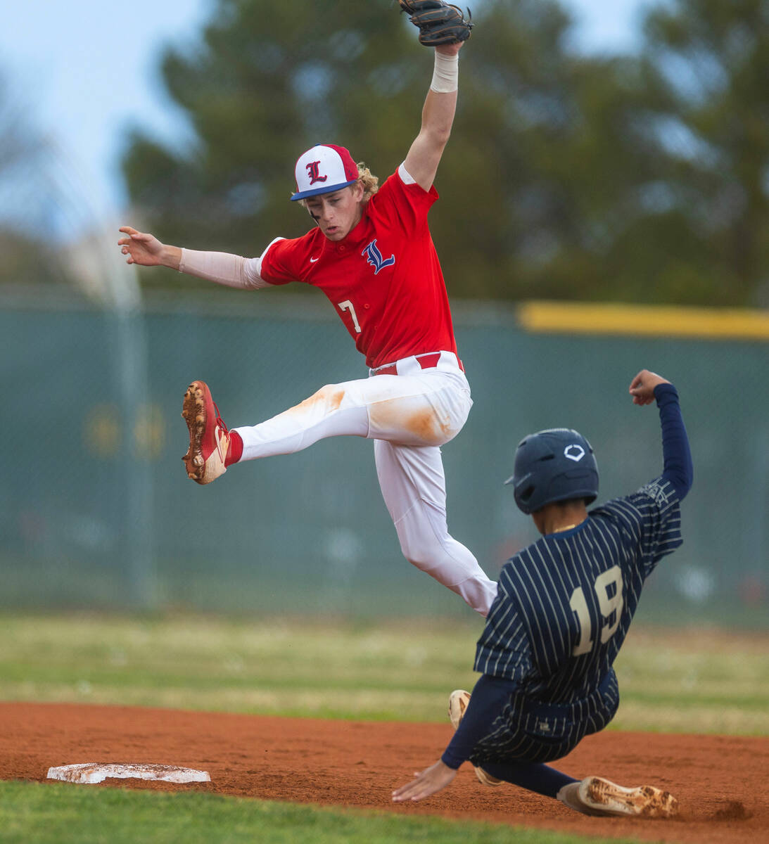 Liberty second baseman Konner Brown goes up high for a possible catch as Spring Valley runner A ...