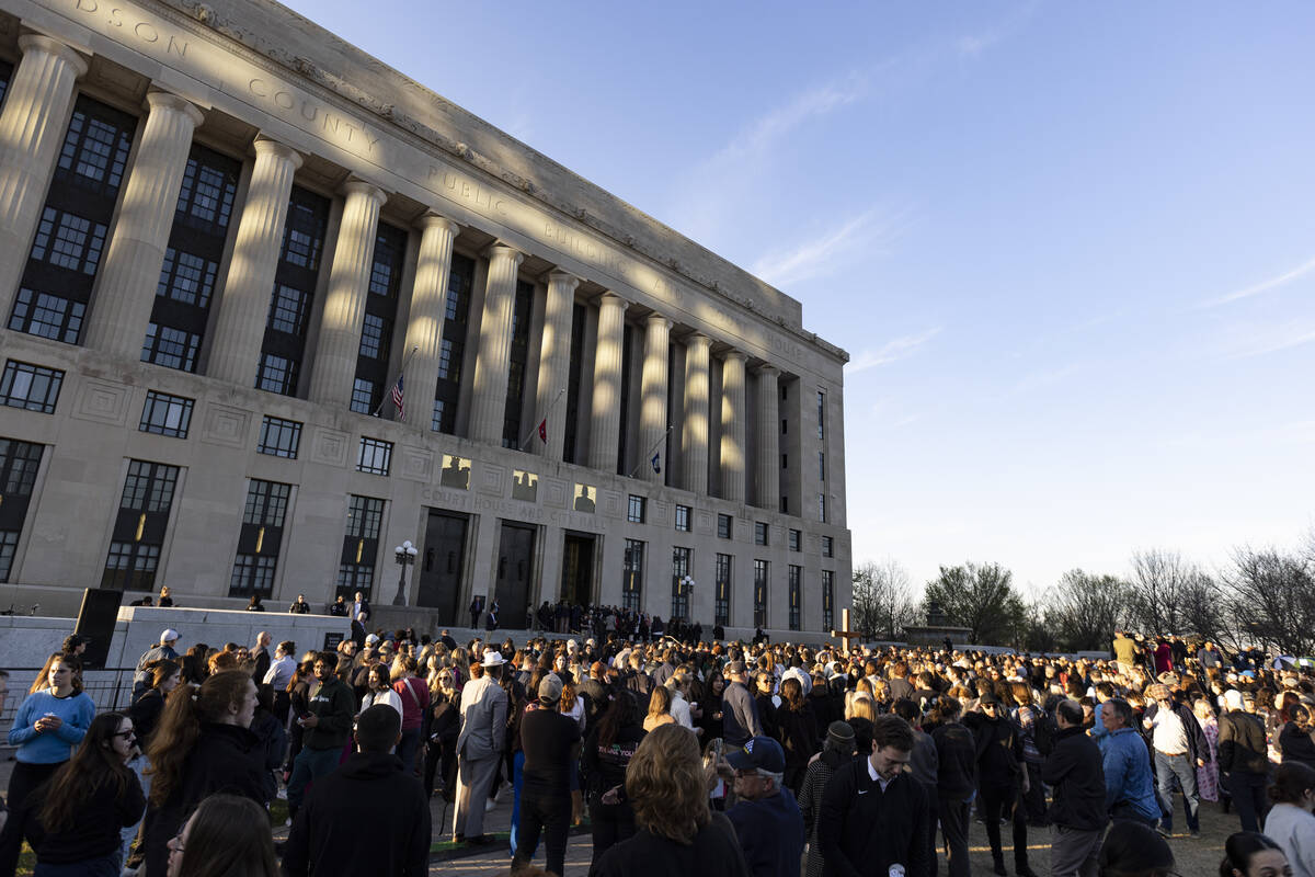 A crowd gathers outside the courthouse and City Hall for a vigil held for victims of The Covena ...