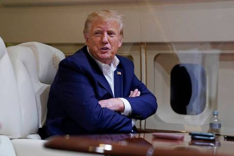 FILE - Former President Donald Trump speaks with reporters while in flight on his plane after a ...