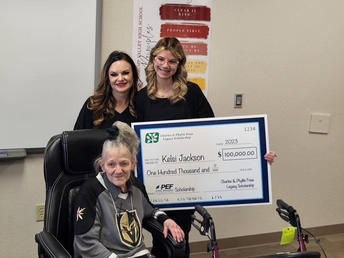 Kelsi Jackson, right, holds the celebratory check with Pahrump Valley High School Principal Des ...