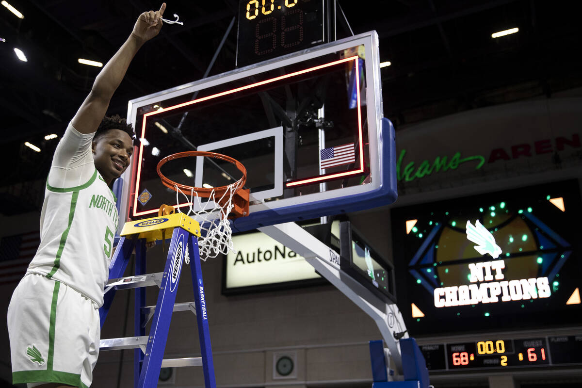 North Texas Mean Green guard Tylor Perry (5) holds his piece of net up after his team won the N ...