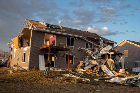 A man takes a picture of storm damage in Hills, Iowa, Friday, March 31, 2023. (Nick Rohlman/The ...
