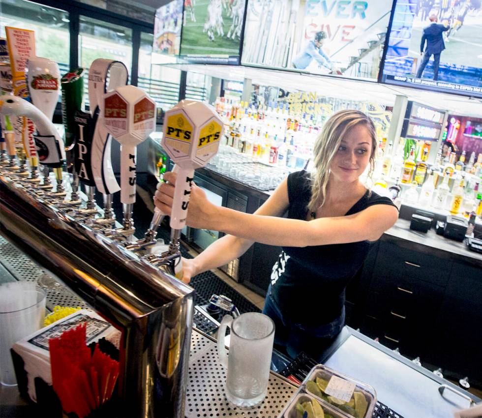 Bartender Bree Barlow menuangkan bir di PT's Tavern, situs bekas Beano's Casino, 7200 ...