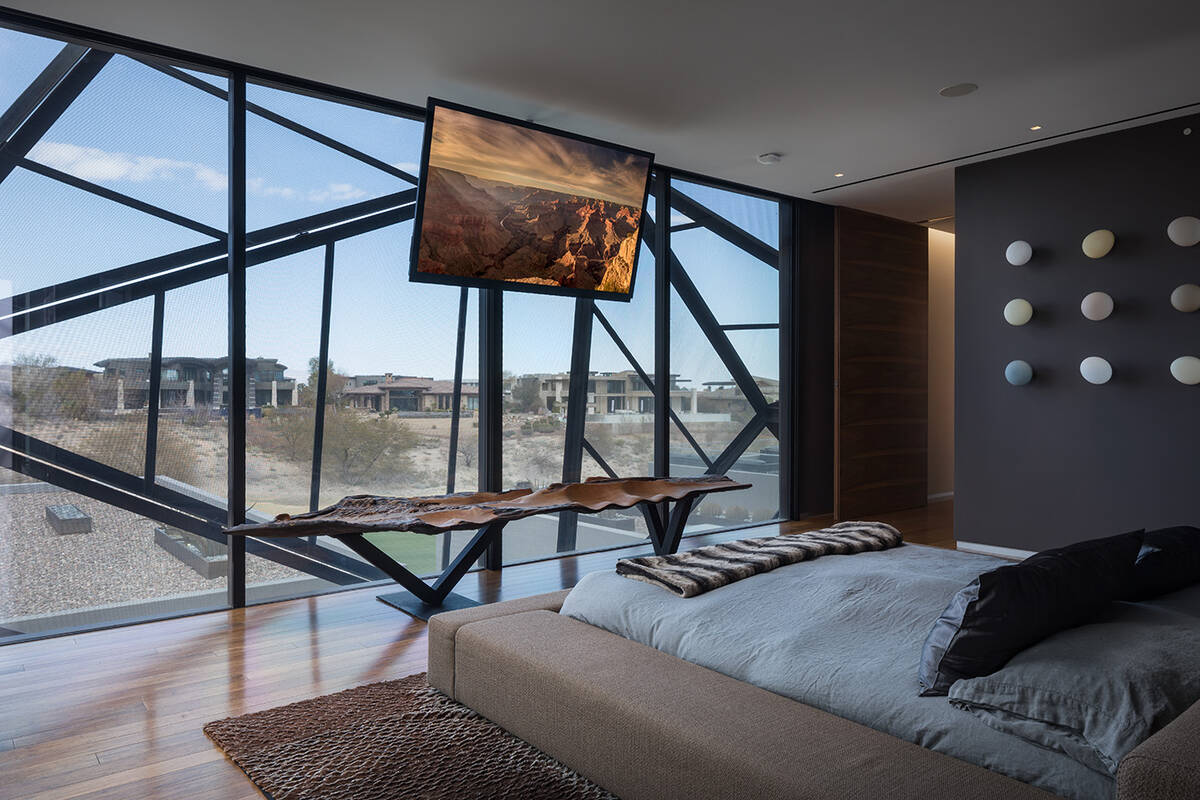 The master bedroom at 20 Soaring Bird features floor-to-ceiling windows with views of the golf ...