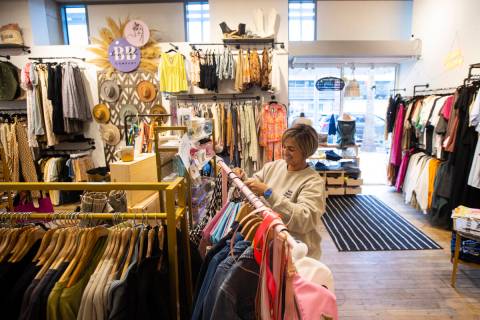 Lauren Tieru, owner of Paige and Rye, organizes a clothing rack at the store in Downtown Summer ...