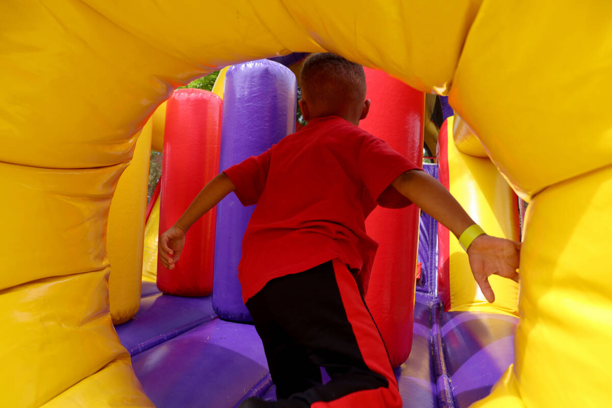 An unidentified foster child enters the bounce house obstacle course as part of a foster parent ...
