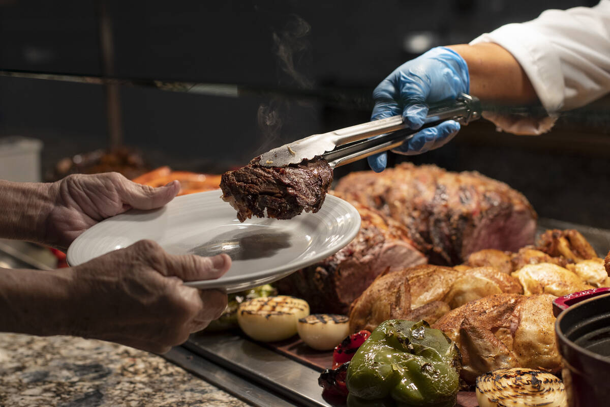 A customer receives a slice of prime rib in the Market Place Buffet at Rampart Casino in 2021 i ...