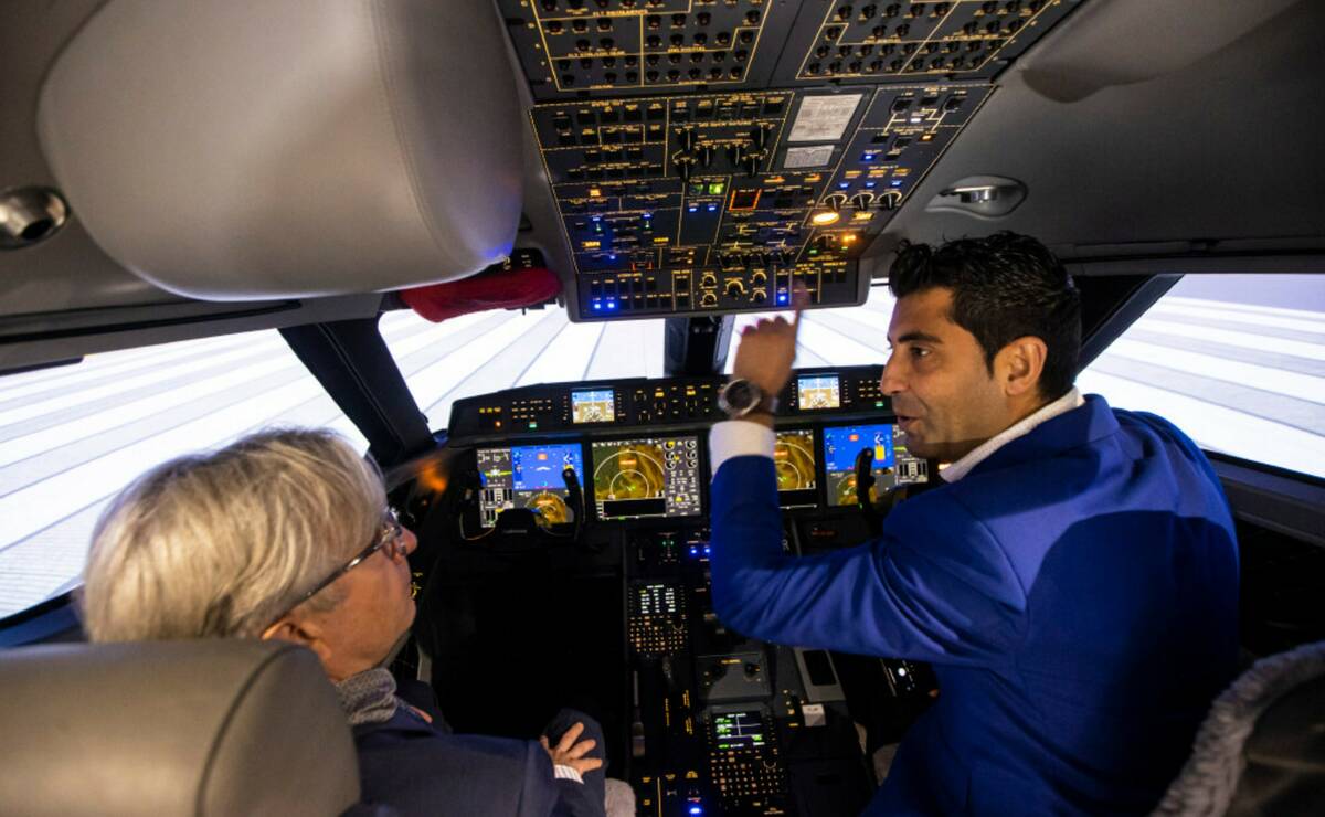 Arash Sadegh, training manager at CAE, right, shows off one of the full-flight simulators to Th ...