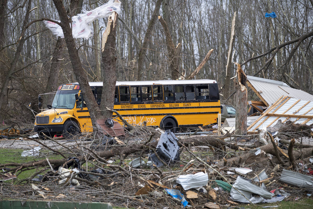 A school bus is surrounded by debris in an area that was heavily damage by a tornado in Sulliva ...