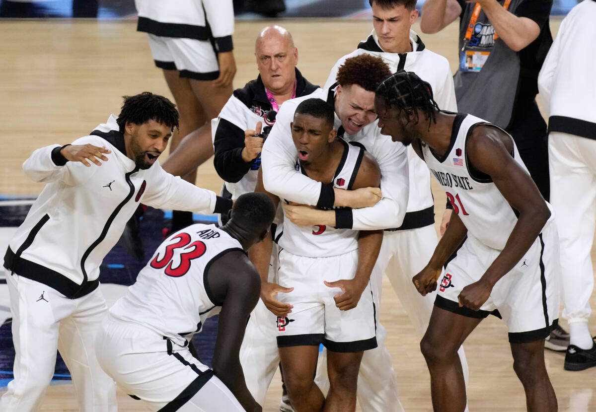 San Diego State guard Lamont Butler, center, celebrates with teammates after he hit the winning ...