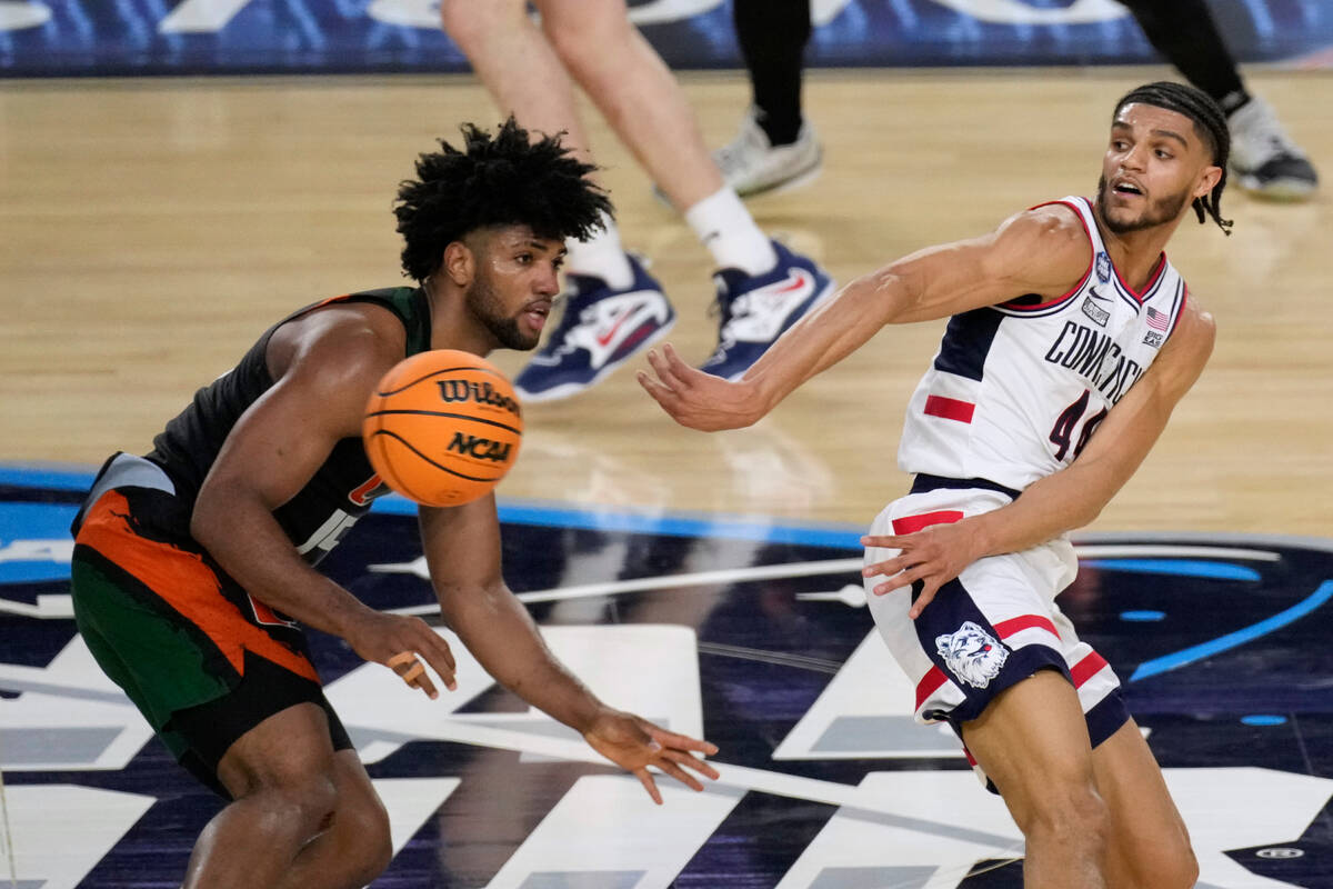 Connecticut guard Andre Jackson Jr. (44) passes around Miami forward Norchad Omier, left, durin ...