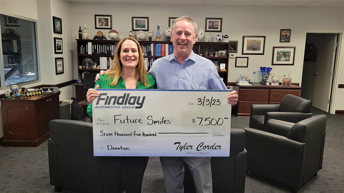 Tyler Corder, right, CFO of Findlay Automotive, presents a donation check to Christine Kenney, ...