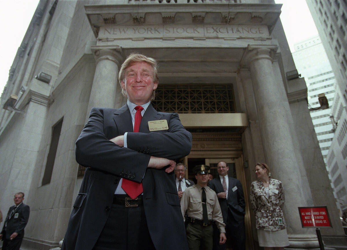 FILE - Developer Donald Trump poses for photos outside the New York Stock Exchange after the li ...
