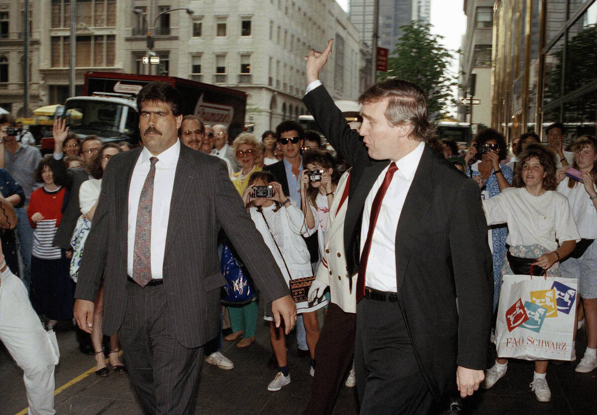 FILE - Donald Trump, right, waves to onlookers while leaving his residence at Trump Tower in Ne ...