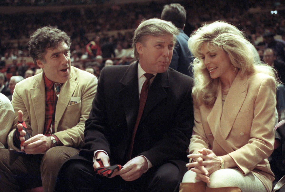 FILE - Actor Elliott Gould, left, joins Donald Trump, center, and Marla Maples at courtside dur ...