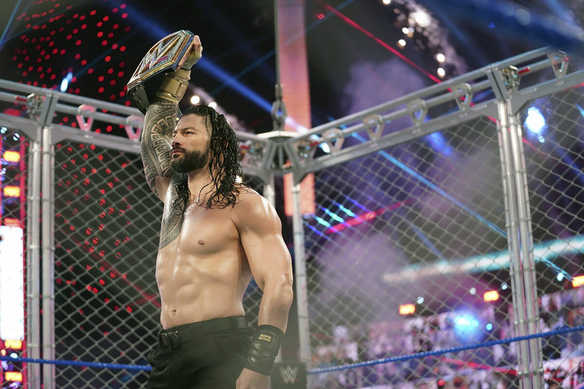 Roman Reigns holds up the WWE Universal Championship after defeating Jey Uso during a match on ...