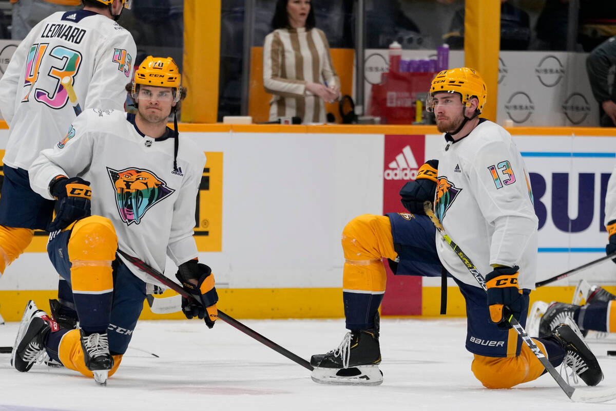 Nashville Predators left wing Egor Afanasyev (70) and center Yakov Trenin (13) wear Pride Night ...